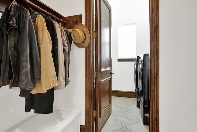 spacious closet featuring independent washer and dryer and light tile patterned flooring