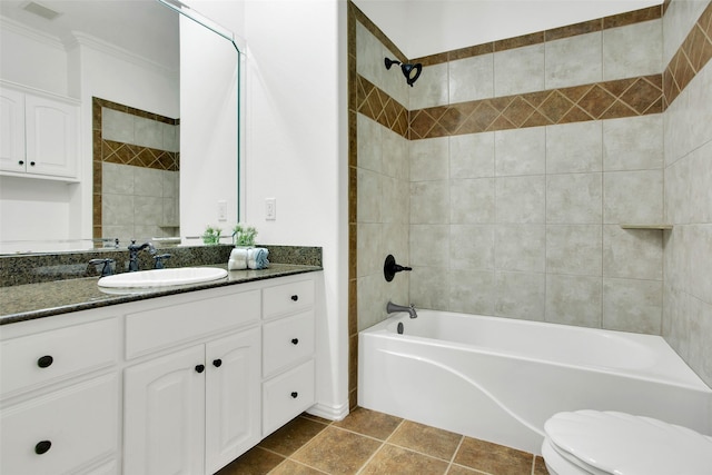 full bathroom featuring tile patterned floors, ornamental molding, vanity, tiled shower / bath combo, and toilet