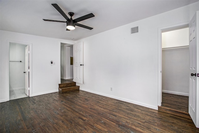 unfurnished bedroom with a closet, dark hardwood / wood-style floors, a spacious closet, and ceiling fan