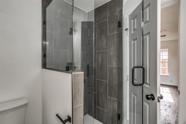 bathroom featuring a tile shower and toilet