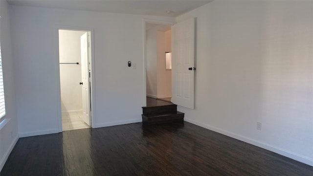 unfurnished room featuring dark wood-type flooring