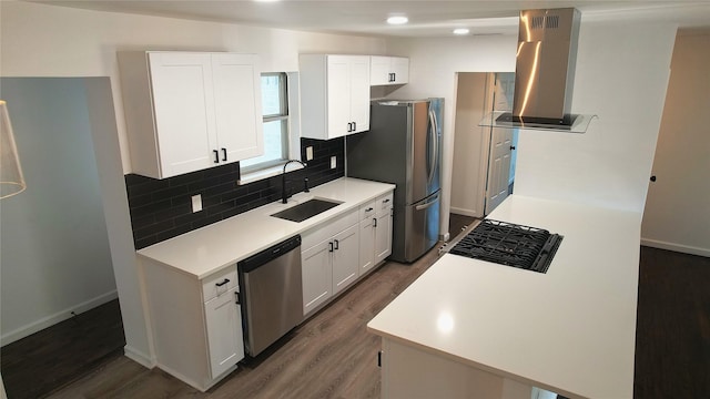 kitchen with dark wood-type flooring, white cabinets, sink, range hood, and stainless steel appliances