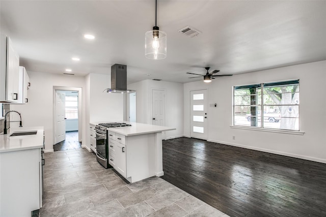 kitchen featuring a wealth of natural light, white cabinetry, stainless steel range with gas cooktop, and exhaust hood