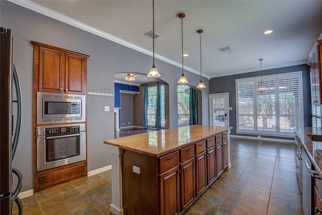 kitchen featuring a center island, hanging light fixtures, appliances with stainless steel finishes, a wealth of natural light, and light stone countertops