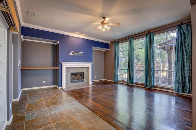 unfurnished living room featuring a fireplace, wood-type flooring, ceiling fan, and crown molding