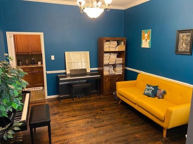 sitting room with crown molding, dark hardwood / wood-style flooring, and an inviting chandelier