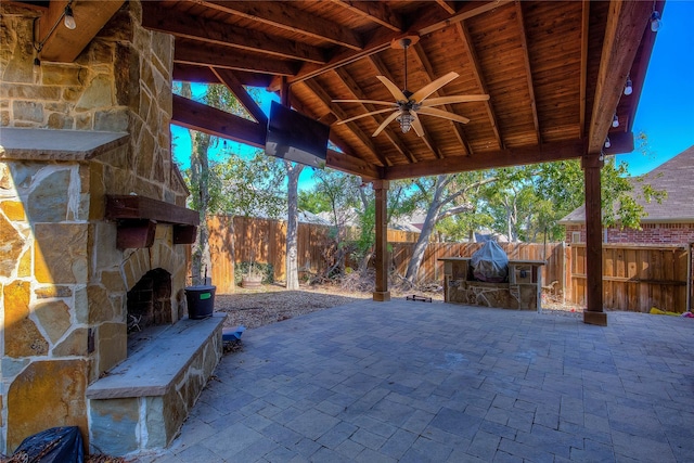 view of patio / terrace featuring a gazebo, ceiling fan, and an outdoor stone fireplace