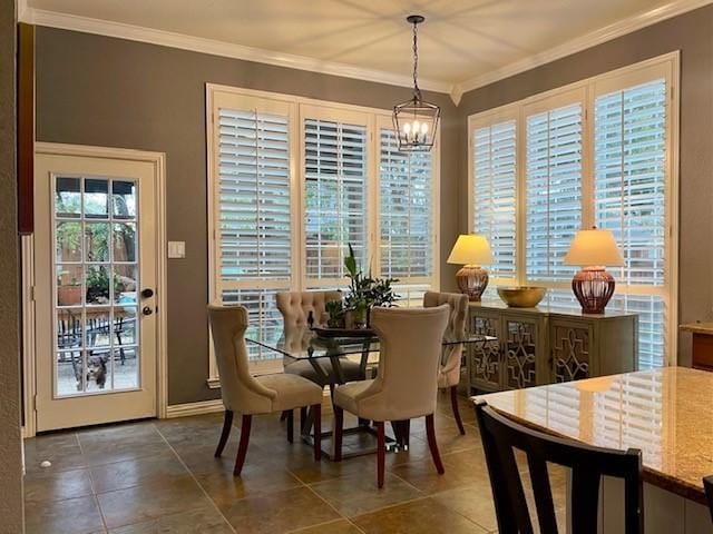 tiled dining room featuring crown molding and a chandelier