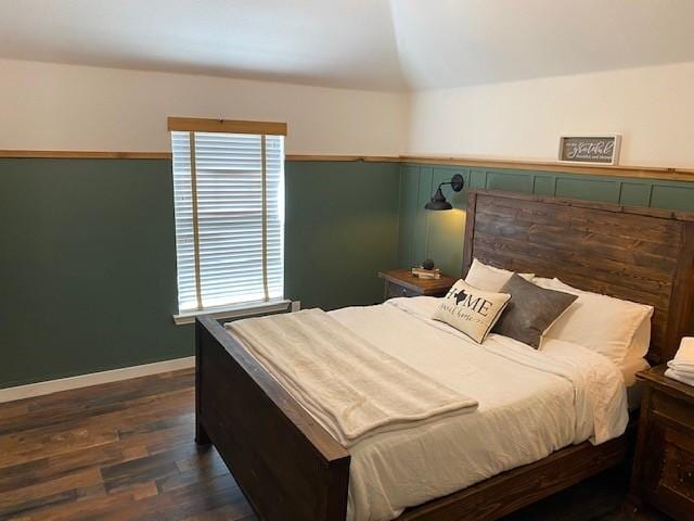 bedroom featuring dark wood-type flooring and vaulted ceiling