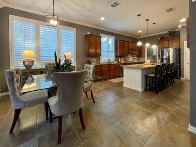 tiled dining room with plenty of natural light and ornamental molding