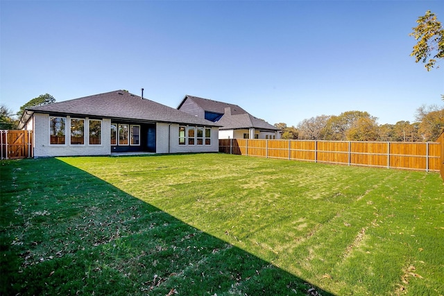 rear view of house featuring a yard