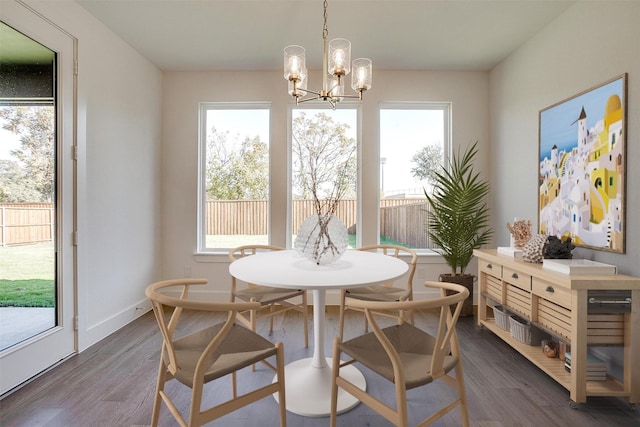 dining space featuring a healthy amount of sunlight, dark wood-type flooring, and an inviting chandelier