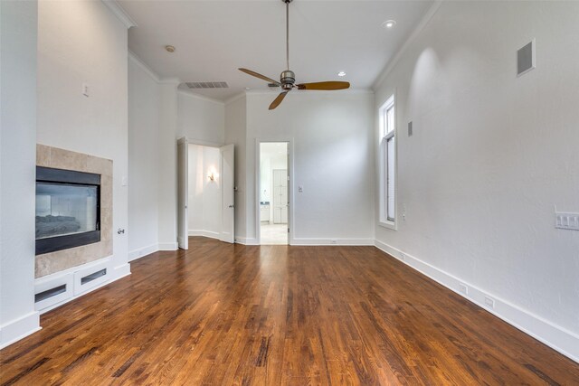 unfurnished living room with ceiling fan, ornamental molding, a fireplace, and dark hardwood / wood-style flooring