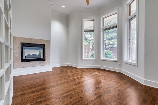 unfurnished living room with crown molding, dark hardwood / wood-style floors, ceiling fan, and a multi sided fireplace