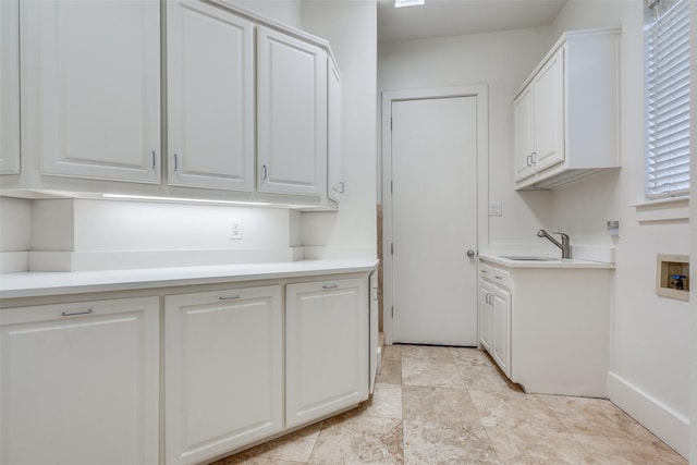 laundry area with cabinets, hookup for a washing machine, and sink