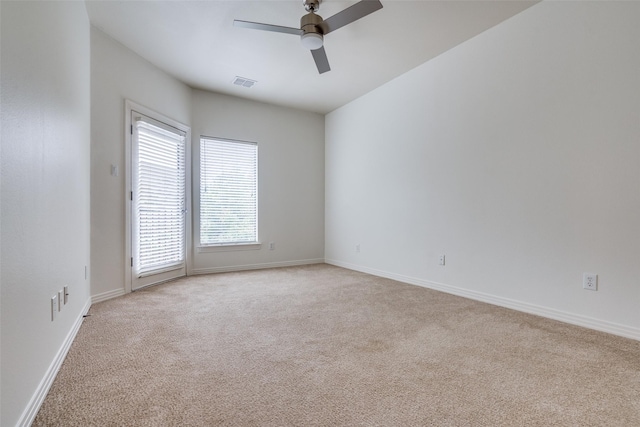 empty room featuring ceiling fan and light carpet