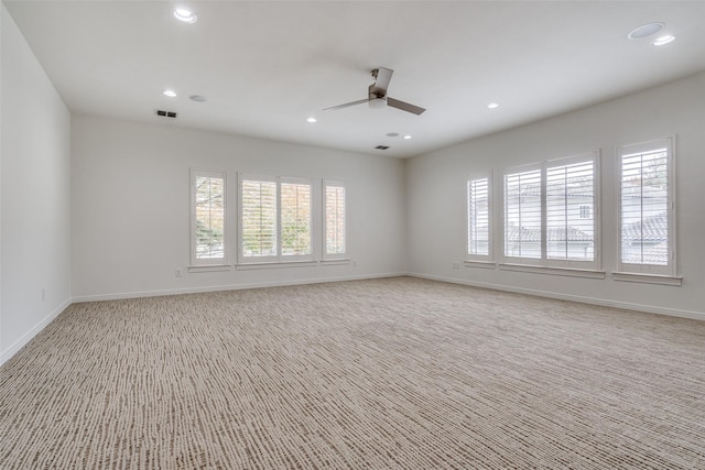 carpeted spare room with ceiling fan