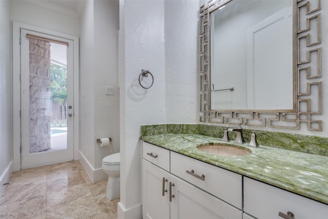 bathroom with vanity, crown molding, and toilet