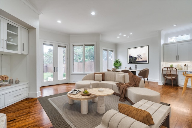 living room with ornamental molding, a healthy amount of sunlight, dark hardwood / wood-style flooring, and french doors