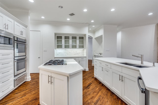 kitchen featuring sink, white cabinetry, tasteful backsplash, stainless steel appliances, and a kitchen island with sink