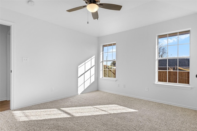 spare room with a wealth of natural light, ceiling fan, and light carpet