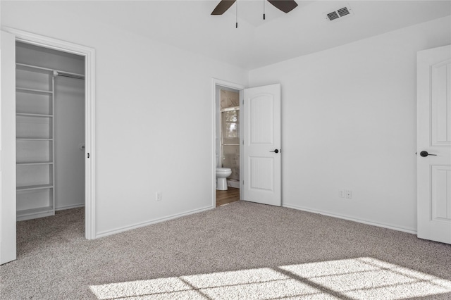 unfurnished bedroom with a spacious closet and carpet