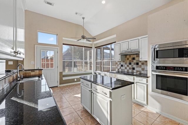 kitchen featuring white cabinetry, a center island, vaulted ceiling, and appliances with stainless steel finishes