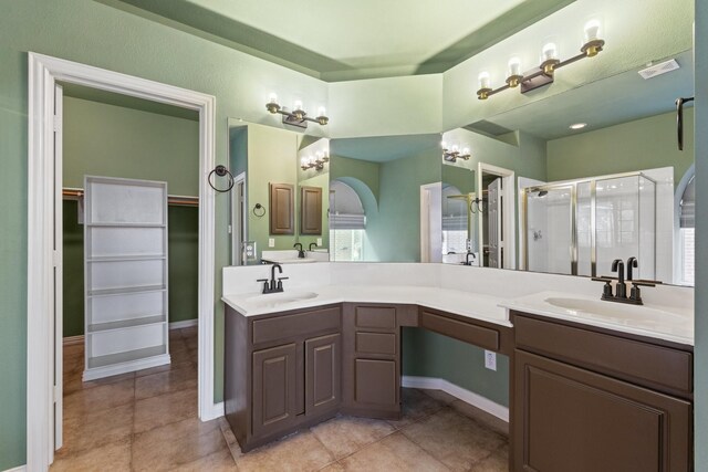 bathroom with tile patterned floors, vanity, an enclosed shower, and an inviting chandelier