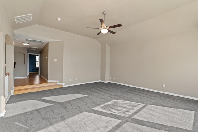 empty room with dark carpet, vaulted ceiling, and ceiling fan