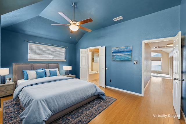 bedroom with ceiling fan, light hardwood / wood-style floors, ensuite bath, and vaulted ceiling