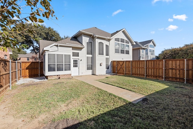 back of property featuring a lawn and a sunroom