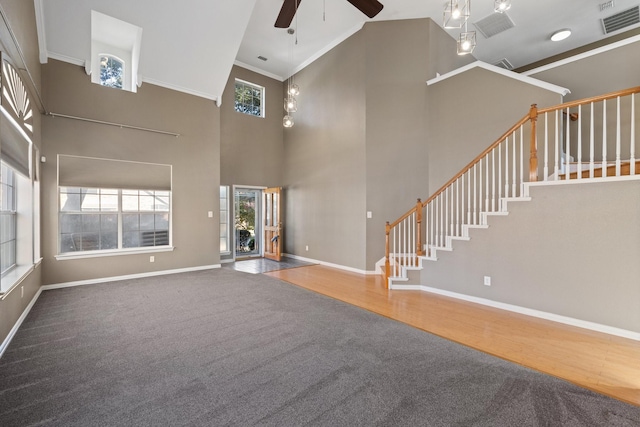 unfurnished living room featuring hardwood / wood-style flooring, ceiling fan, and high vaulted ceiling