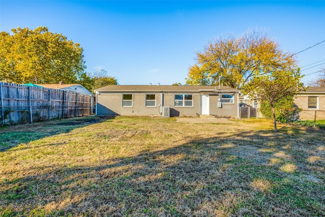 back of property with a yard and central air condition unit