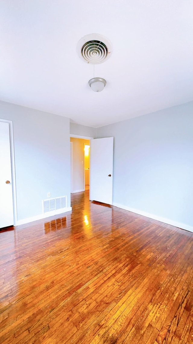 empty room with hardwood / wood-style flooring