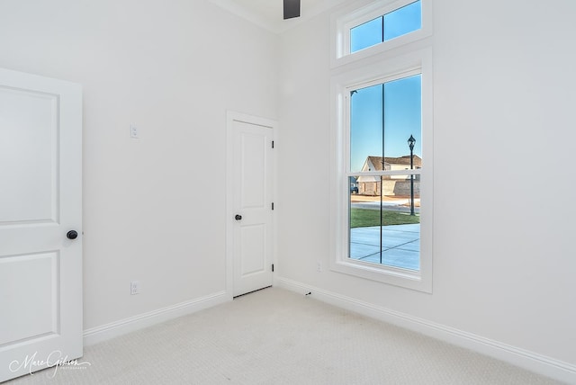 unfurnished room with light carpet and baseboards