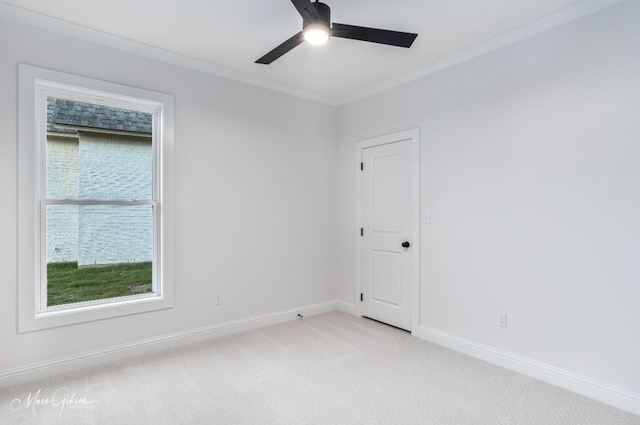 empty room featuring ceiling fan, crown molding, baseboards, and light carpet