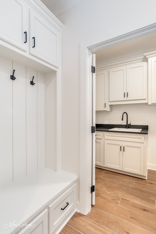 mudroom with light wood-type flooring and a sink