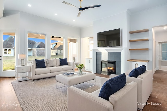 living room with a fireplace, a ceiling fan, and wood finished floors