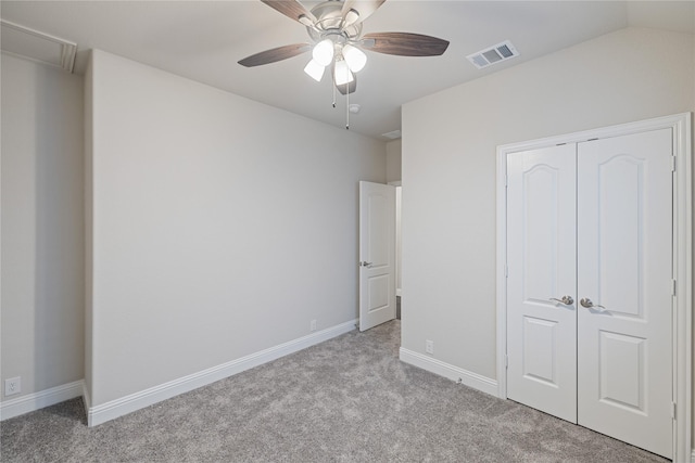 unfurnished bedroom with vaulted ceiling, light colored carpet, ceiling fan, and a closet