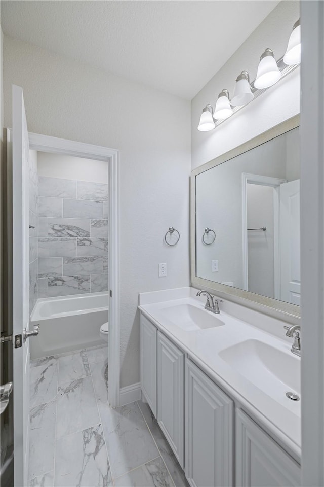 full bathroom featuring tiled shower / bath, vanity, toilet, and a textured ceiling