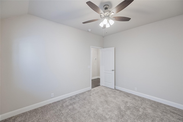 empty room with vaulted ceiling, ceiling fan, and carpet