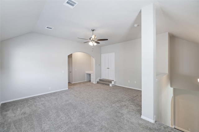 carpeted empty room with ceiling fan and vaulted ceiling