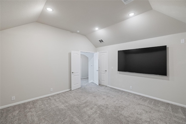 unfurnished bedroom featuring lofted ceiling and carpet floors