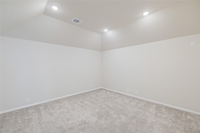 carpeted empty room featuring vaulted ceiling