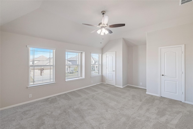 interior space featuring ceiling fan, lofted ceiling, and light carpet