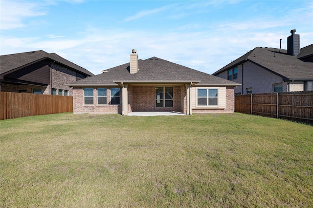 rear view of house with a yard and a patio