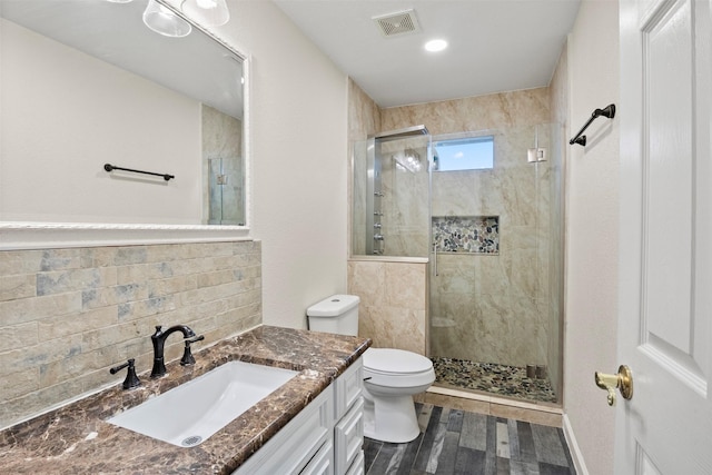 bathroom with tasteful backsplash, wood-type flooring, vanity, an enclosed shower, and toilet