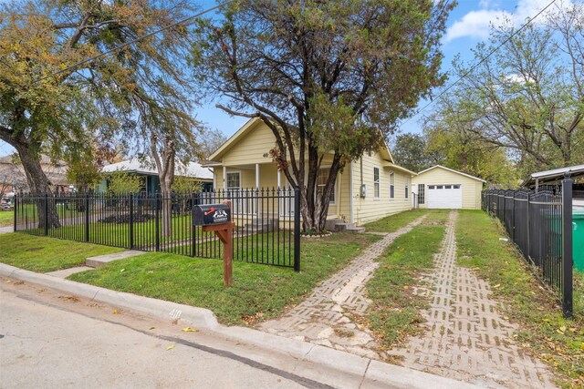 bungalow-style home with a porch, a garage, an outdoor structure, and a front lawn