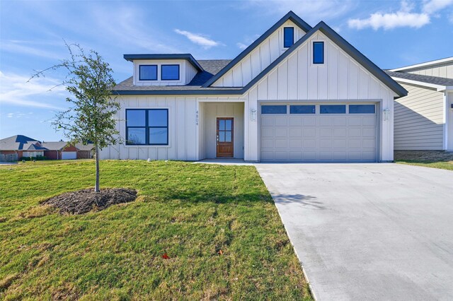 modern inspired farmhouse with a front yard and a garage