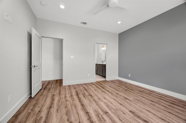 unfurnished bedroom with ceiling fan, connected bathroom, and light hardwood / wood-style floors